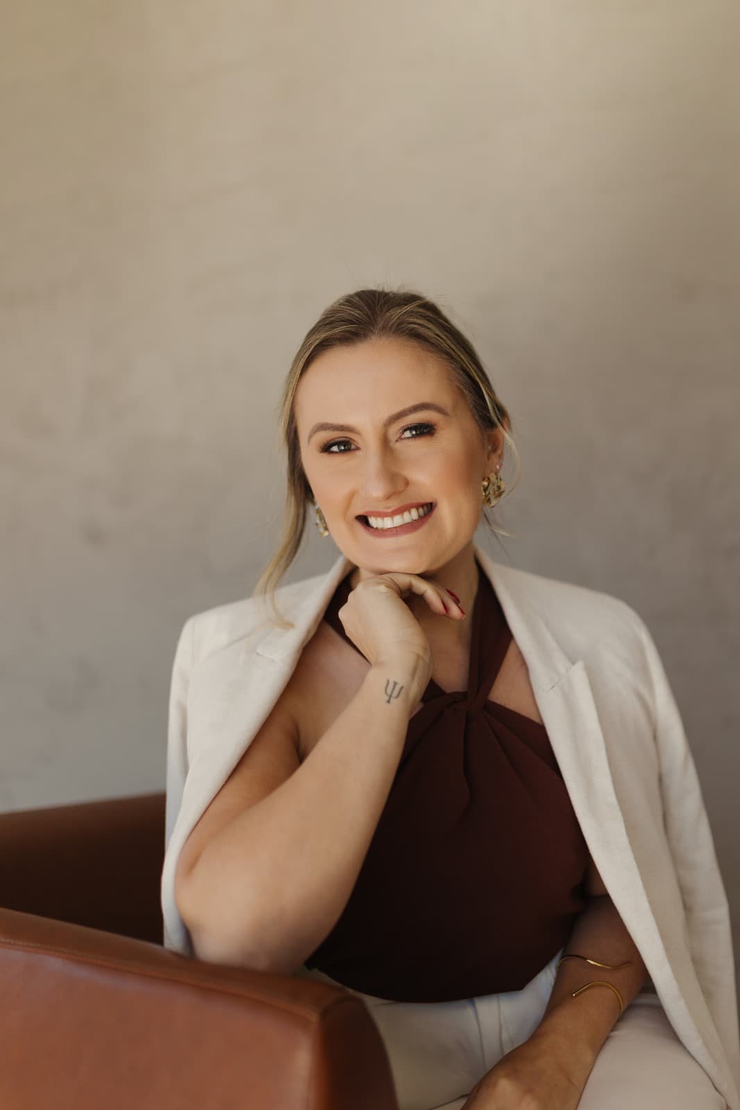 Mulher sorrindo, sentada em uma poltrona